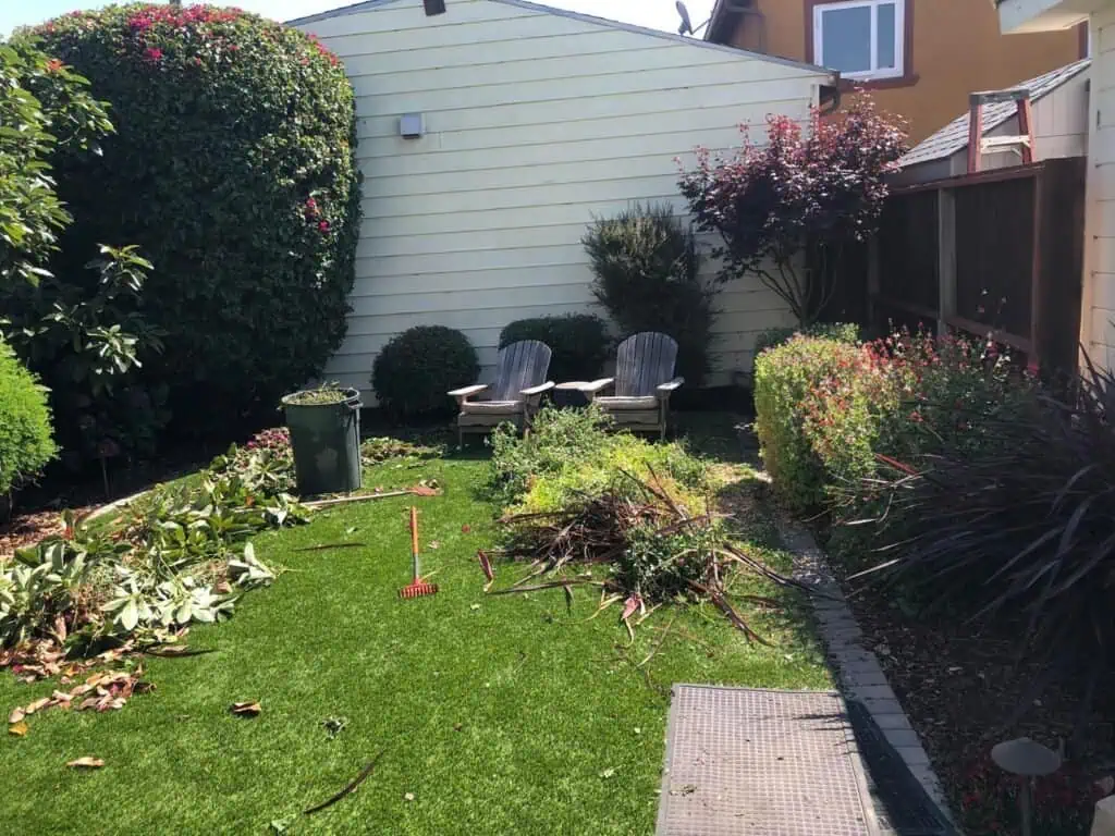 Beautiful landscaped backyard featuring manicured lawn, flowering shrubs, and garden furniture, maintained by Green Leaf Landscaping.
